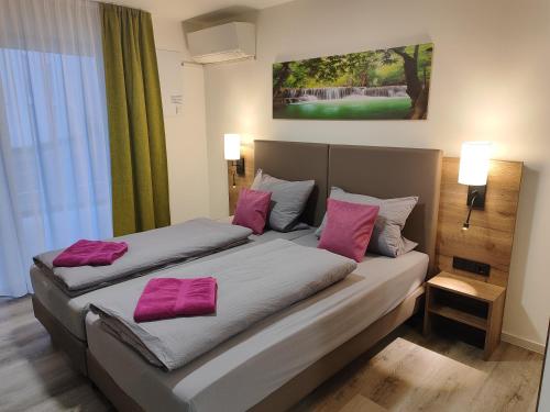 腓特烈港Hotel Gästehaus Stock Zimmer Wasserfall的两张位于酒店客房的床,配有粉红色枕头