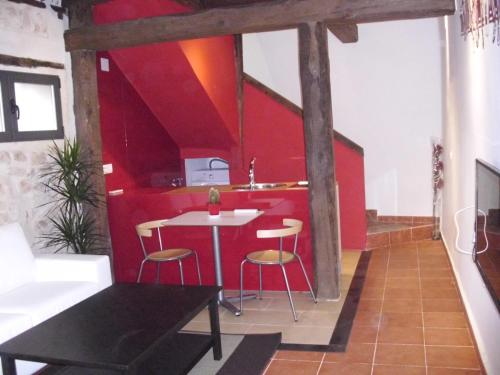 Cabañas de PolendosCasa Rural con Jacuzzi La Dulce的厨房设有红色的墙壁和桌椅