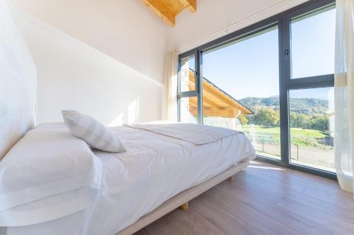 AravellCasa rural de lujo en Alt Urgell, Pirineos.的卧室配有白色的床和大窗户