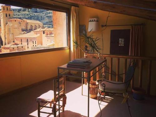 阿尔巴拉辛圣地亚哥之家酒店的客房设有桌子、椅子和窗户。