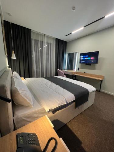 阿克套Caspian Marine Hotel的酒店客房设有一张大床和一台电视。