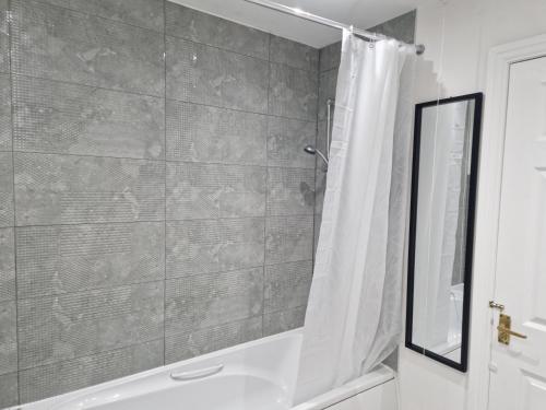 斯陶尔波特Charming Home in Stourport Sleeps10 with Wifi&Parking by PureStay Short Lets的浴室配有淋浴帘和浴缸。
