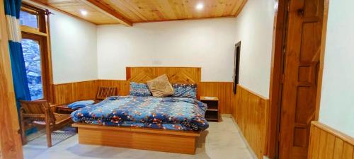 卡索尔MOKSHA COTTAGES AND WOODHOUSE的一间卧室配有一张带蓝色棉被的床