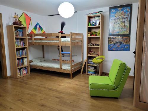 法鲁彩色一室公寓的客房设有双层床和绿椅。