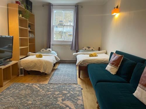 伦敦15 min to The Heart of London - Charming 2 bed Apartment的一间带两张床和一张沙发的客厅