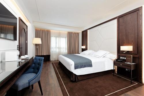 马德里马德里克拉里奇酒店的配有一张床和一张书桌的酒店客房