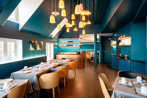 圣马洛Hôtel de la Cité的餐厅拥有蓝色的墙壁和桌椅