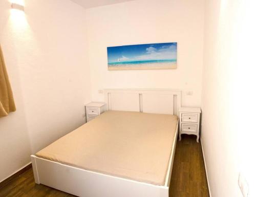 圣特雷莎加卢拉Grazioso bilocale a Santa Teresa di Gallura的一间小卧室,配有一张床和墙上的绘画