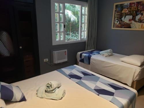 圣劳伦斯海滨Amarilis Flat Maravilhoso - com serviço de hotelaria, sauna e piscinas climatizadas的一间设有两张床铺和毛巾的房间