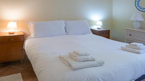 康特港Adelia的卧室配有白色床和毛巾
