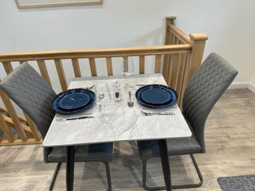 帕兹托HeyRic的一张带两把椅子的白色桌子和蓝色的盘子