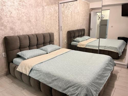 克拉约瓦White & Elegant Luxury Apartament Decomandat的一间卧室配有两张床和镜子