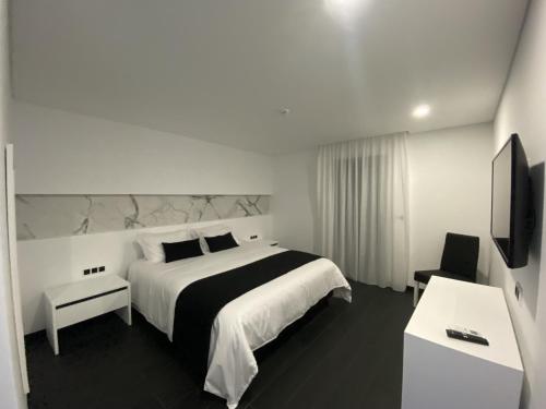 蓬塔德尔加达The Rock Hostel的酒店客房设有一张大床和一台电视。
