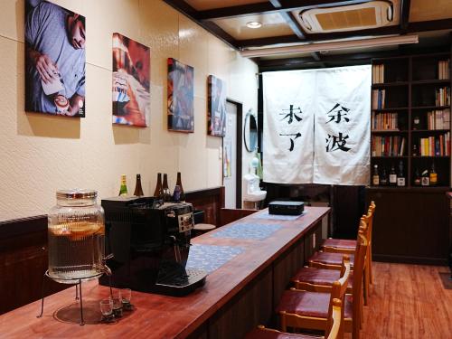 神户KOBE coffee hostel的餐厅里的酒吧,墙上写着书