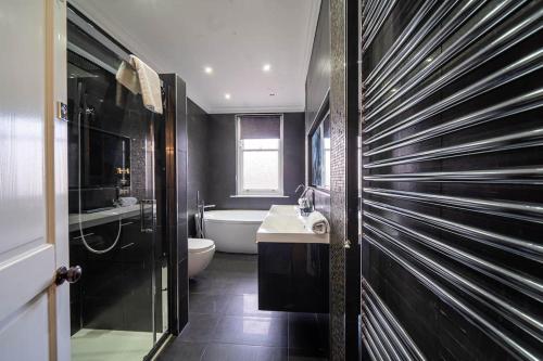 谢菲尔德Bannerdale Villa - Sheffield的带浴缸、卫生间和盥洗盆的浴室