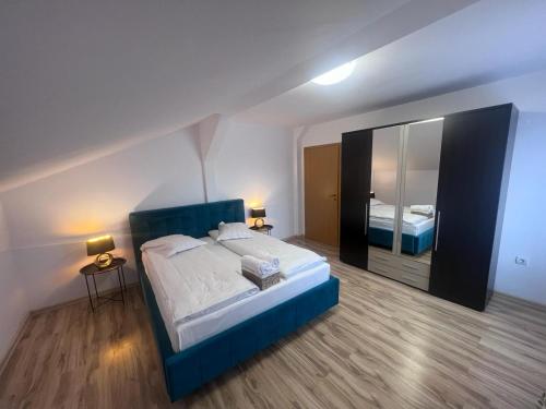 锡比乌Helix Apartaments的一间卧室配有一张大床和镜子