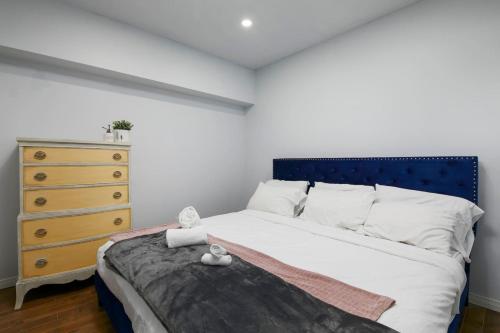 蒙特朗布朗The Nordic 2BR Chalet by Instant Suites - 5 min to Tremblant Village的一间卧室配有一张带蓝色床头板的床和梳妆台