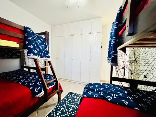 BombitaPERLA MARINA BEACH的一间卧室配有双层床和红色床垫