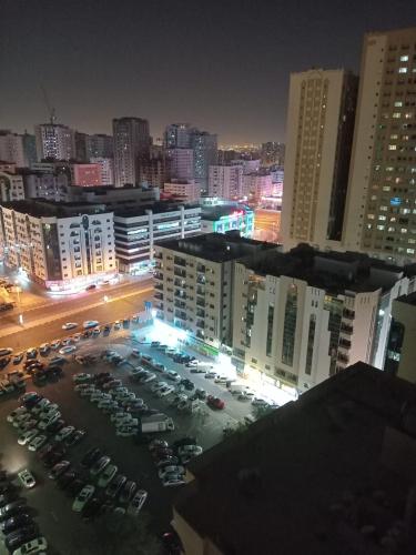 沙迦SHARING BED SPACE FOR MALE near DUBAI BUS STOP的夜间停车的城市