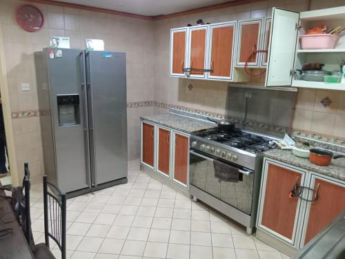 沙迦SHARING BED SPACE FOR MALE near DUBAI BUS STOP的厨房配有不锈钢用具和棕色橱柜