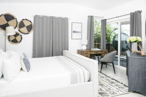 EnighedIsland Oasis: Beach & Views的白色卧室配有白色的床和书桌