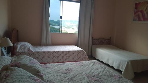 波苏阿莱格里Suíte próxima à Univas/Fátima的小房间设有两张床和窗户