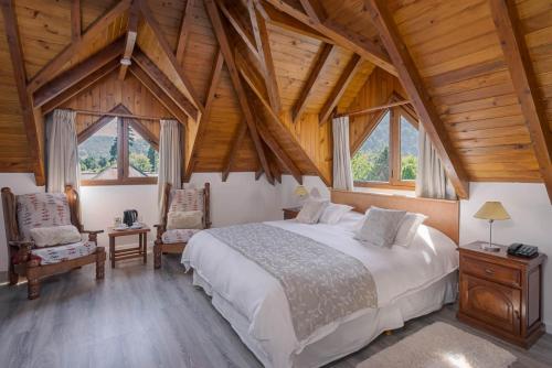 圣马丁德洛斯夏特勒酒店的一间带一张大床的卧室,位于一个拥有木制天花板的房间