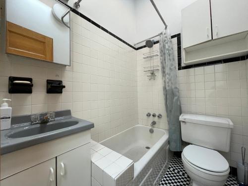 纽约Large Room in Charming Townhouse的浴室配有盥洗盆、卫生间和浴缸。