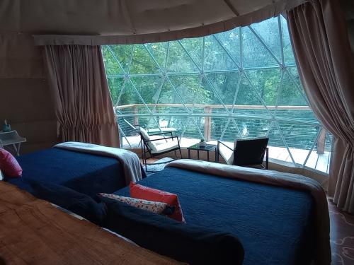 SuttonGlampOut Resort - Elk River的一间卧室设有两张床和大窗户
