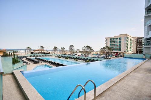北马马亚-讷沃达里NorthBay Sunrise View - Infinity Pool & Spa Resort的一座带椅子和建筑的大型游泳池