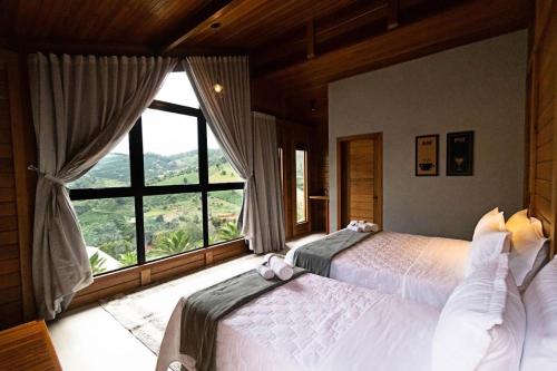 DivisaVilla di Madeira的一间卧室设有两张床和大窗户