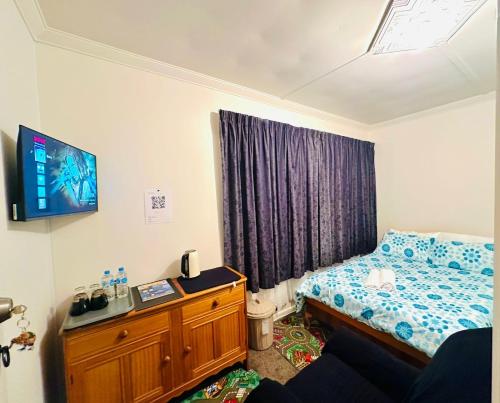 因弗卡吉尔Double bed room in Invercagill/5mini walk to city的卧室配有一张床,墙上配有电视。
