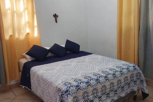 奇南德加Charming 3 bedroom house的一间卧室配有一张带蓝色枕头的床。