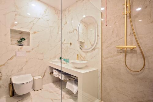 奥拉迪亚Hotel Artemis的带淋浴、卫生间和盥洗盆的浴室