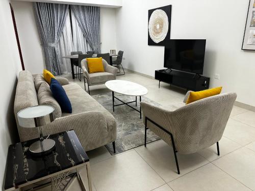 马斯喀特City Gem BAQ的客厅配有沙发、椅子和电视