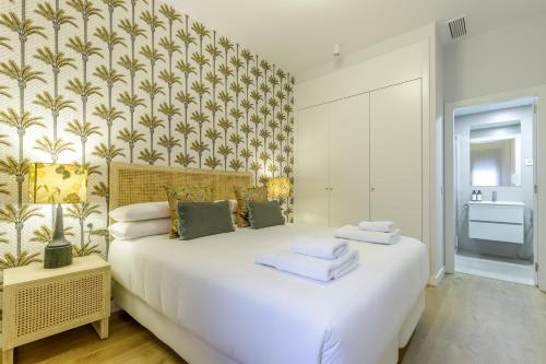 马拉加Malagueta Miramar with Shared Pool by Caleta Homes的卧室配有一张白色大床和壁纸