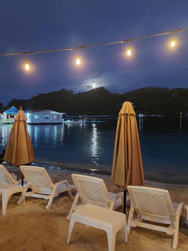 格兰德岛Casa de playa的一群椅子和遮阳伞在晚上在海滩上