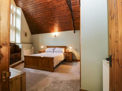 卡林顿Frogwell Chapel的一间卧室设有一张床和木制天花板