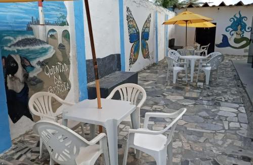 萨尔瓦多hostel quintal da sereia的庭院配有白色的桌椅和遮阳伞。