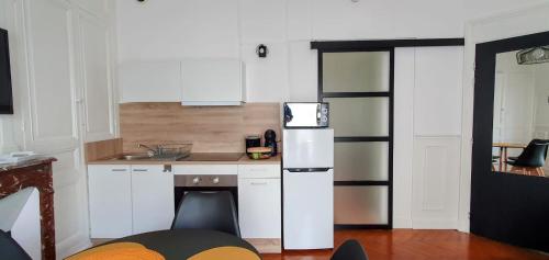 勒特雷波尔Entre 2 flots 1的厨房配有白色橱柜和白色冰箱。
