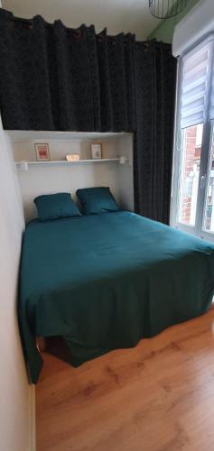 勒特雷波尔Entre 2 flots 1的一间卧室配有一张带蓝色枕头的床和一扇窗户。