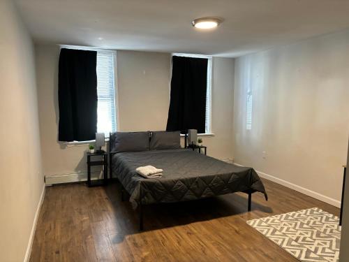 波士顿3 HOMESTAY At Boston In Dorchester or JFK-UMASS or South Boston的一间卧室设有一张床和两个窗户。