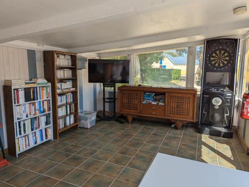 Plomeur澜汶露营酒店的一间带电视和书架的客厅