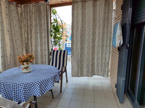巴里亚纳Habitación en un Ático con gran terraza y,cocina ,en la playa的一张桌子,上面有蓝白的桌布