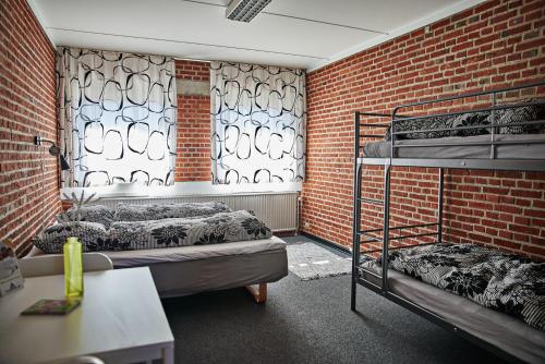 格林斯泰兹Danhostel Grindsted-Billund的带两张双层床和砖墙的客房