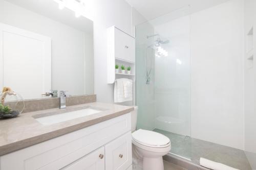 西湾Summertime Suites #49的白色的浴室设有卫生间和水槽。