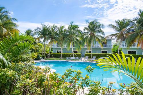 西湾Summertime Suites #50的棕榈树建筑前的游泳池