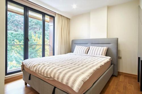 伊斯坦布尔Privat 3 Bedroom Duplex Apartment at Ulus Beşiktaş的一间卧室设有一张床和一个大窗户