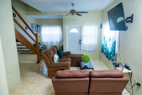 拉纳韦贝Emerald inn at runaway bay的客厅配有两张沙发和一台电视机