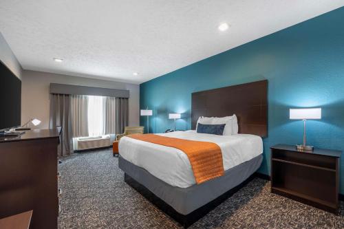 欧文斯伯勒Best Western Plus Owensboro的酒店客房设有一张大床和蓝色的墙壁。